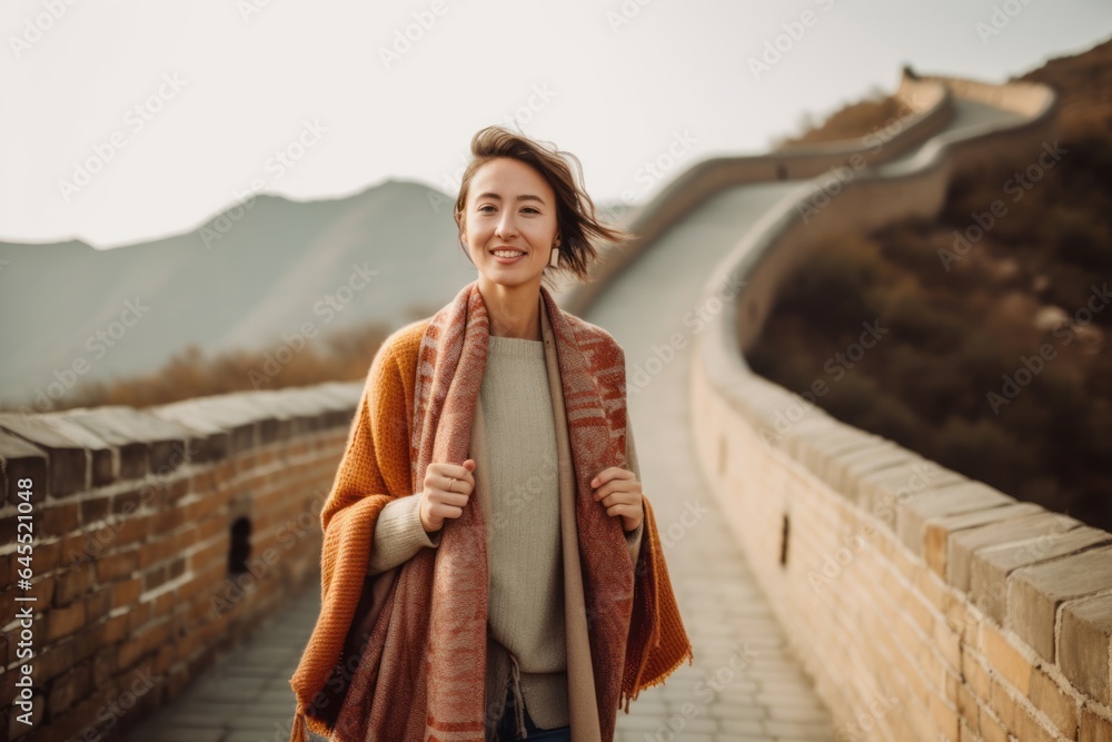 Fototapeta premium Lifestyle portrait photography of a pleased woman in her 30s that is wearing a chic cardigan at the Great Wall of China in Beijing China