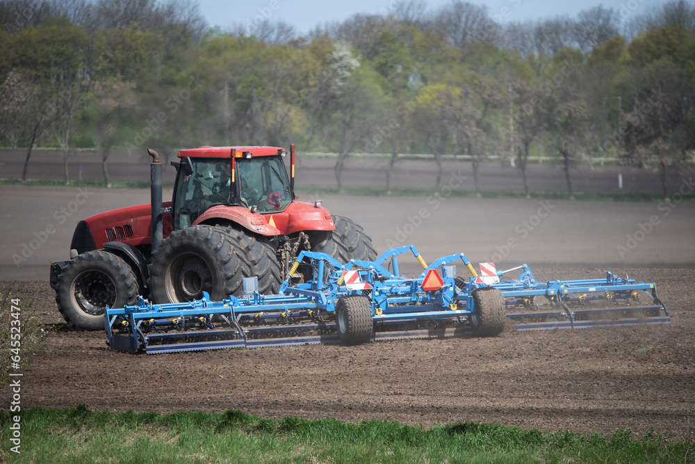 Fototapeta premium Farming Precision: Tractor's Careful Soil Cultivation