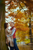 smiling stylish boyfriend and girlfriend in park hugging