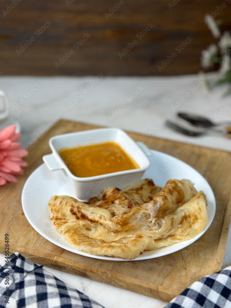 Roti Parata or Roti canai with curry sauce, a popular Malaysian breakfast