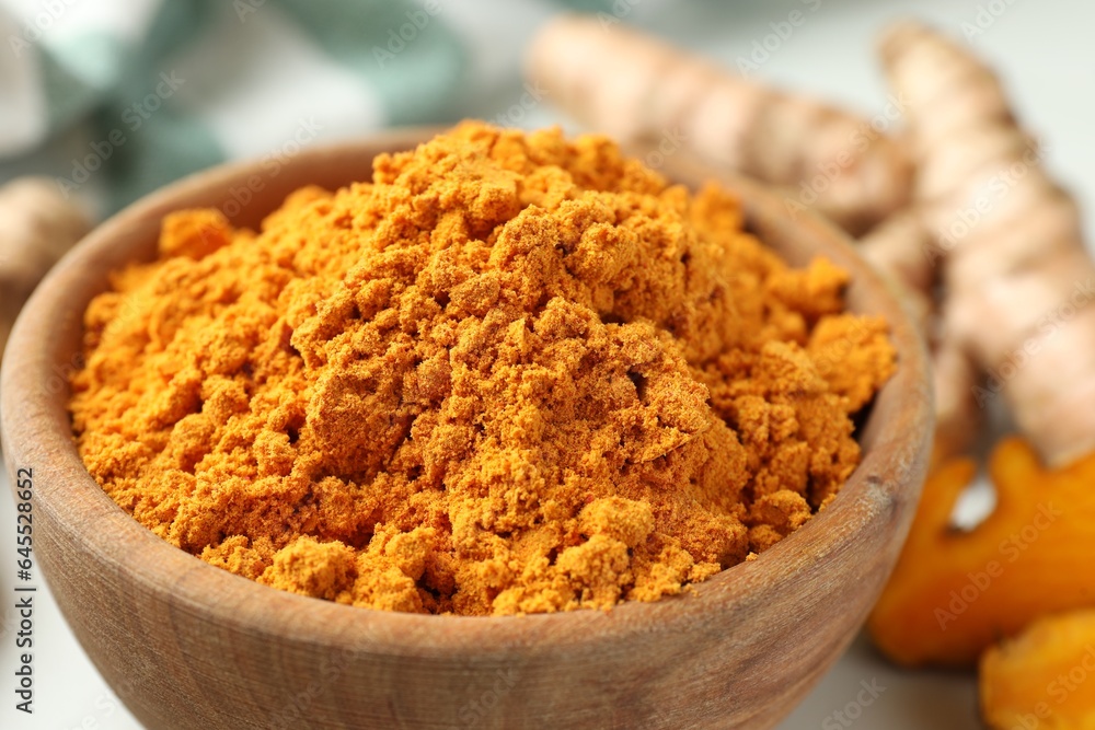 Aromatic turmeric powder in bowl on table, closeup Aromatic turmeric powder in bowl on table, closeup