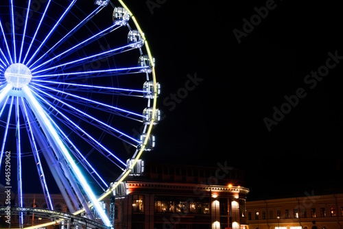 Beautiful glowing Ferris wheel in city at night. Space for text