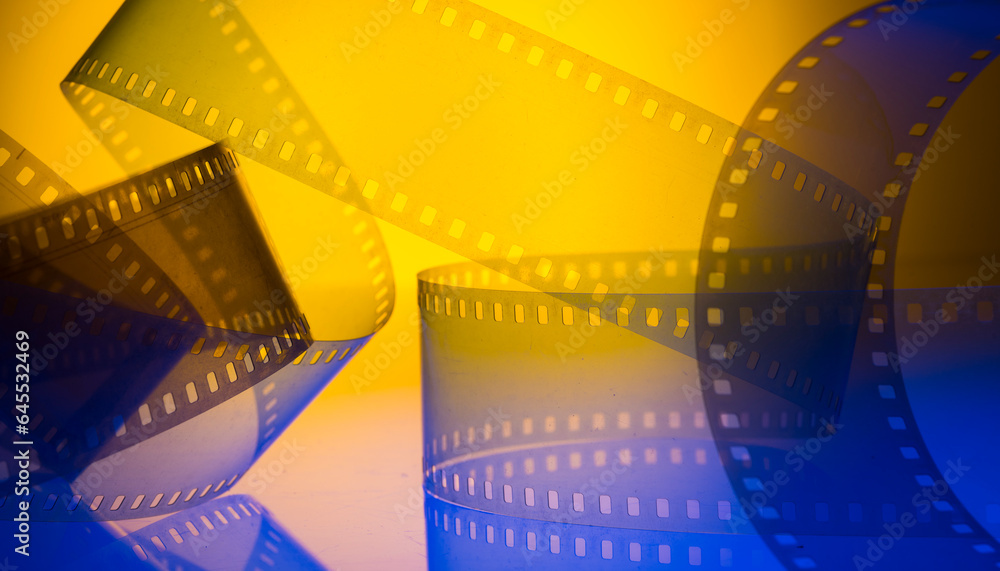yellow-blue colored background with film strip. cinematography premiere film production show industry concept.abstract background with film strip - obrazy, fototapety, plakaty 