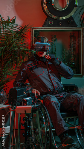 Cybernetization and isolation. A man in a wheelchair with a virtual reality helmet on his head, high technology and a low standard of living of society, concept