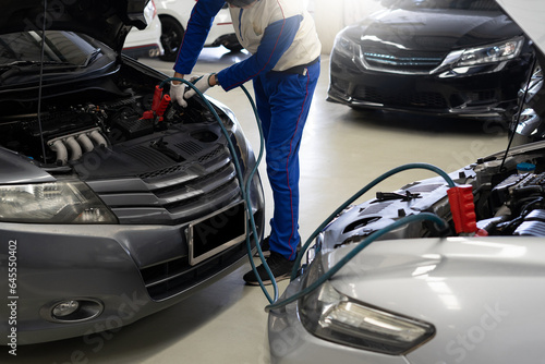 Close-up of a mechanic hand charging a car battery Car repair with jumper cables for transportation