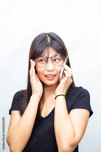 Cheerful business asian woman in casual shirt talking on smartphone
