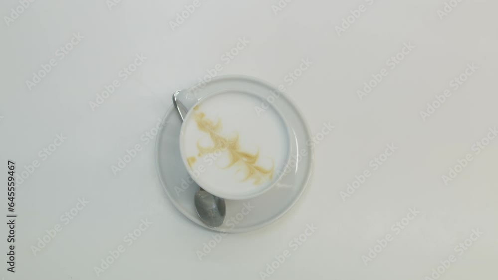 Top view of female waitress or canteen worker putting cup of coffee with latte art on white table. Barista serves cappuccino to visitor. Work in coffee shop, cafe in hospital or modern medical center. Top view of female waitress or canteen worker putting cup of coffee with latte art on white table. Barista serves cappuccino to visitor. Work in coffee shop, cafe in hospital or modern medical center.