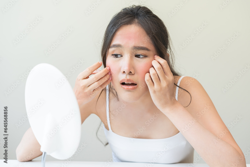 Dermatology, scratch asian young woman looking at mirror, expression worry and itch, itchy allergy or allergic sensitive reaction, red spot or rash on her face. Beauty care from skin problem treatment Dermatology, scratch asian young woman looking at mirror, expression worry and itch, itchy allergy or allergic sensitive reaction, red spot or rash on her face. Beauty care from skin problem treatment