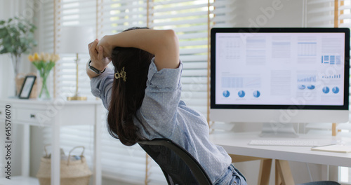 Asia people workforce young woman remote work at home office sit easy relax enjoy break time life balance put hands behind head and lean back on cozy desk. Teen girl stress relief look at desktop PC.