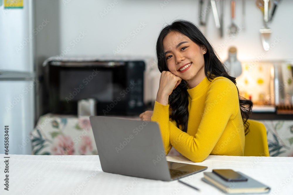 Young Asian businesswoman working using laptop computer on desk at freelance home. Relax. Stretching. Lifestyle of women studying and doing business online business and education concept Young Asian businesswoman working using laptop computer on desk at freelance home. Relax. Stretching. Lifestyle of women studying and doing business online business and education concept