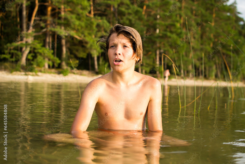 Fototapeta premium Camping weekend, teenage boy, lake and sandy shore.