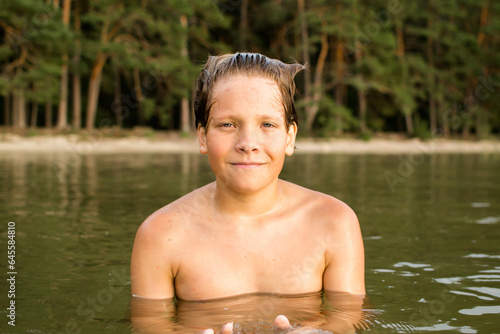 Camping weekend, teenage boy, lake and sandy shore.