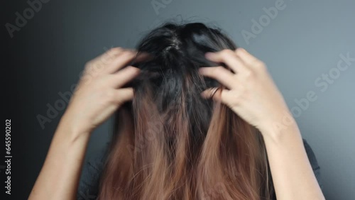 Asian girl with a comb and problem hair on gray background. Asian young woman holding brush, hairbrush with long loss hair problem after brushing.