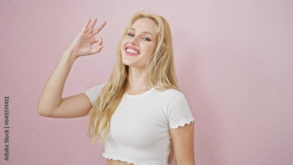 Young blonde woman smiling with ok gestur over isolated pink background Young blonde woman smiling with ok gestur over isolated pink background