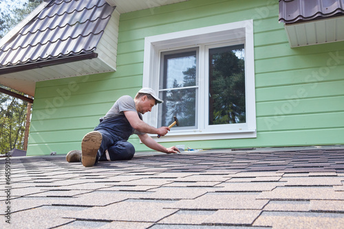A worker greases the roof of the terrace with mastic.