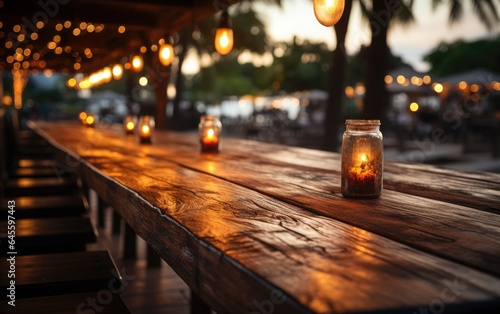 Empty wooden table and bokeh lights blurred outdoor cafe background. High quality photo