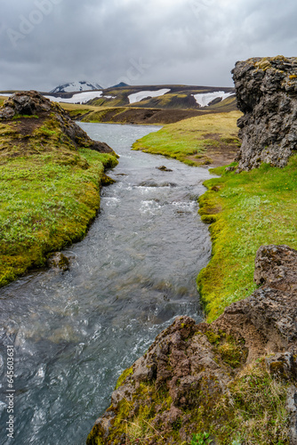 Landmannalaugar, Iceland. Panoramic view at beautiful Icelandic landscape of colorful rainbow volcanic Landmannalaugar mountains and water stream at hiking trail with lava and meadow fields