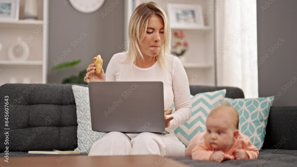 Mother and daughter using laptop eating croissant sitting together at home Mother and daughter using laptop eating croissant sitting together at home