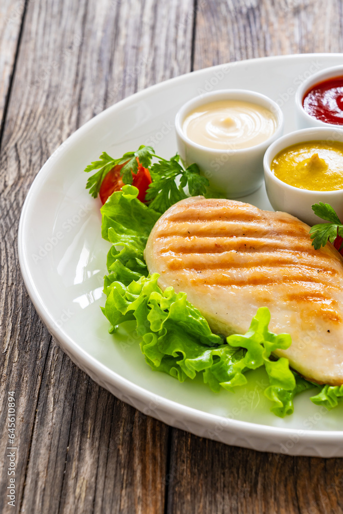 Grilled chicken breast, French fries and fresh vegetables on wooden table
Grilled chicken breast, French fries and fresh vegetables on wooden table