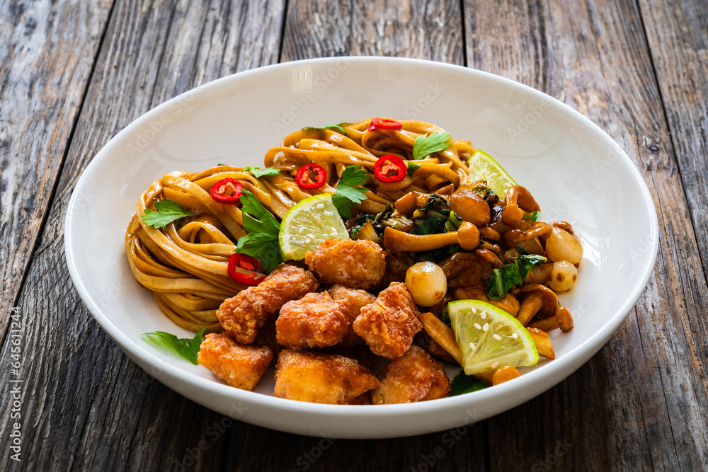 Asian food - chicken nuggets, noodles and fried shimeji mushrooms on wooden table
Asian food - chicken nuggets, noodles and fried shimeji mushrooms on wooden table