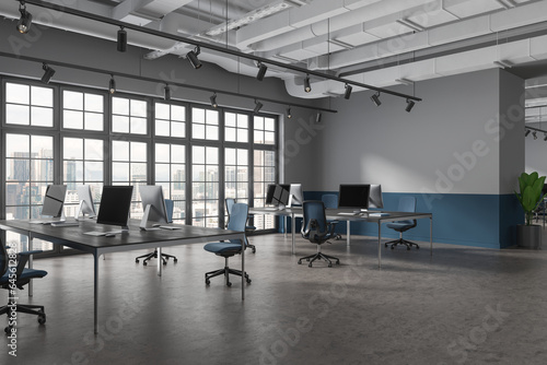 Grey office interior with pc computers and furniture, panoramic window