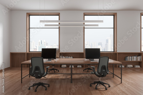 Stylish office interior with desk and chairs, sideboard near panoramic window