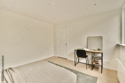 a bedroom with a bed  desk and mirror in the corner of the room on the left is a window