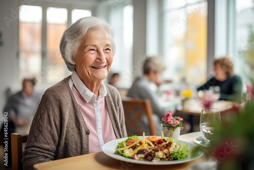 Senior woman in a retirement home, happily enjoying a healthy lunch, showcasing a lifestyle of well-being and contentment
