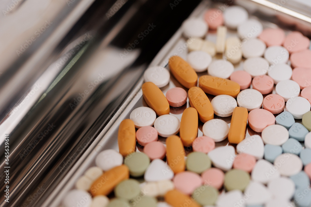Macro Shot of colour Pills and Capsules During Production and Packing Process on Modern Pharmaceutical Factory. Tablet and Capsule Manufacturing Process. Close-up Shot of Medical Drug Production Line.