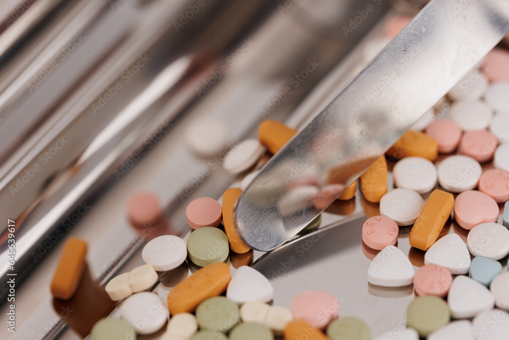 Macro Shot of colour Pills and Capsules During Production and Packing Process on Modern Pharmaceutical Factory. Tablet and Capsule Manufacturing Process. Close-up Shot of Medical Drug Production Line.
