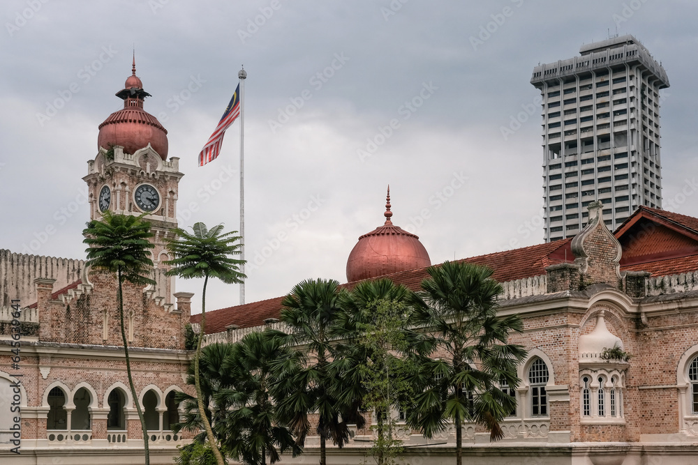 View of Sultan Abdul Samad Building and Malaysian flag on cloudy day. Kuala Lumpur, Malaysia.