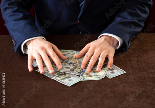 A businessman holding money, on the table.