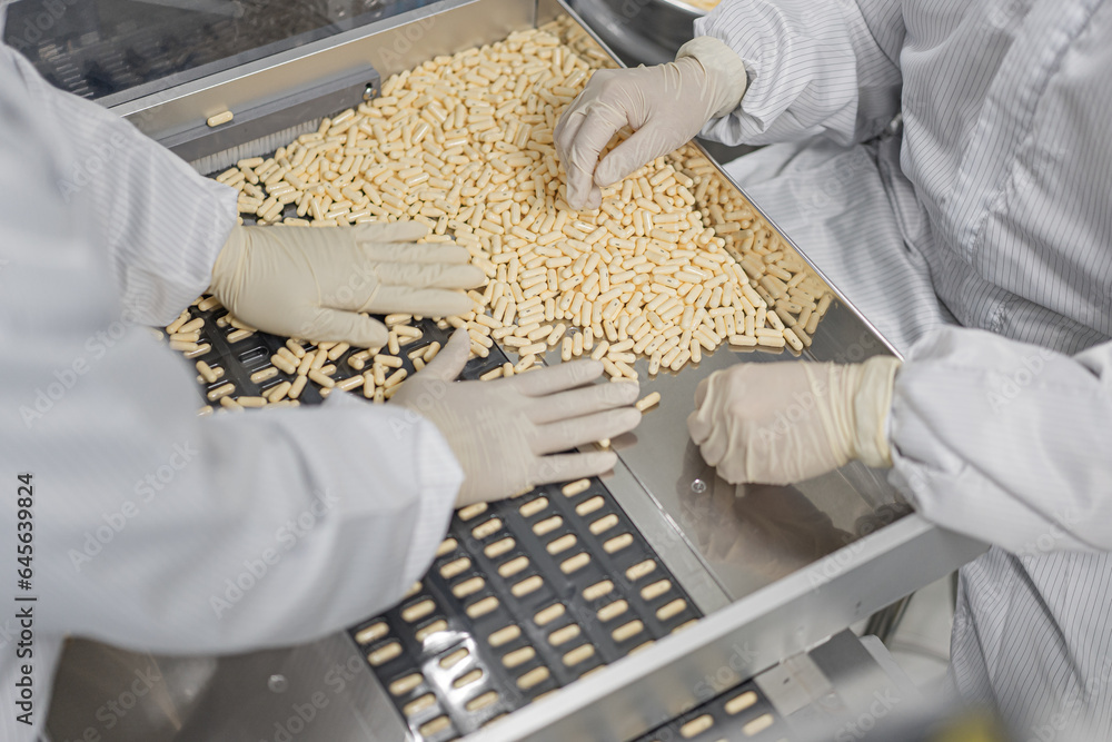 Macro Shot of colour Pills and Capsules During Production and Packing Process on Modern Pharmaceutical Factory. Tablet and Capsule Manufacturing Process. Close-up Shot of Medical Drug Production Line.