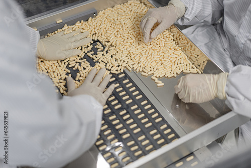Macro Shot of colour Pills and Capsules During Production and Packing Process on Modern Pharmaceutical Factory. Tablet and Capsule Manufacturing Process. Close-up Shot of Medical Drug Production Line.