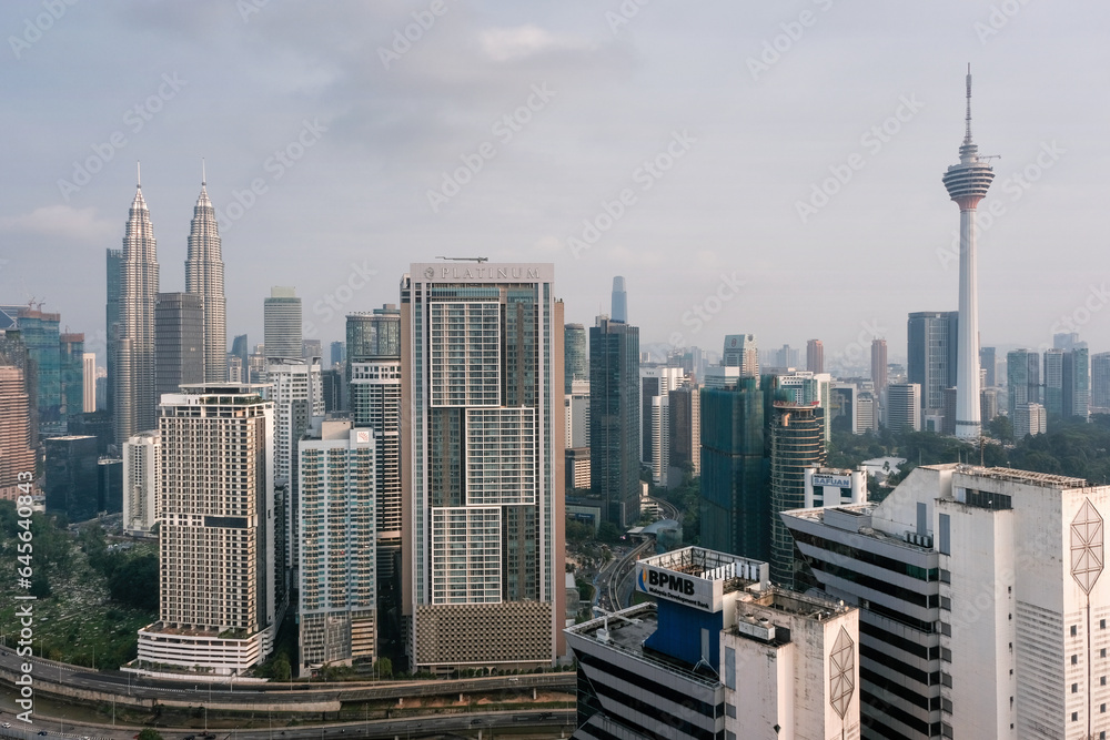 Naklejka premium View of the city and Petronas Twin Towers and Kuala Lumpur Tower on sunny day. Kuala Lumpur, Malaysia.