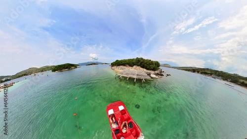 couple on serene Pedal Boat trip in the Ksamil islands. They pedal gently through turquoise waters, basking in the warm sun and exploring hidden coves and picturesque beaches in Albania. DRONE VIEW photo