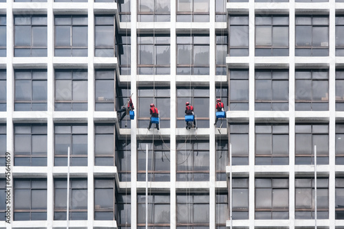 Photography Industrial climbers wash the windows of a multi-storey building on cloudy day