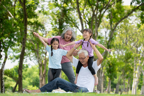 Happy Asian family children having fun and playing with her grandparents in the park © surachetkhamsuk