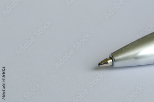 Close-up of silver pen on white notepad with customizable space for text or ideas. Copy space.
