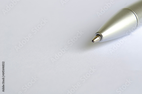 Close-up of silver pen on white notepad with customizable space for text or ideas