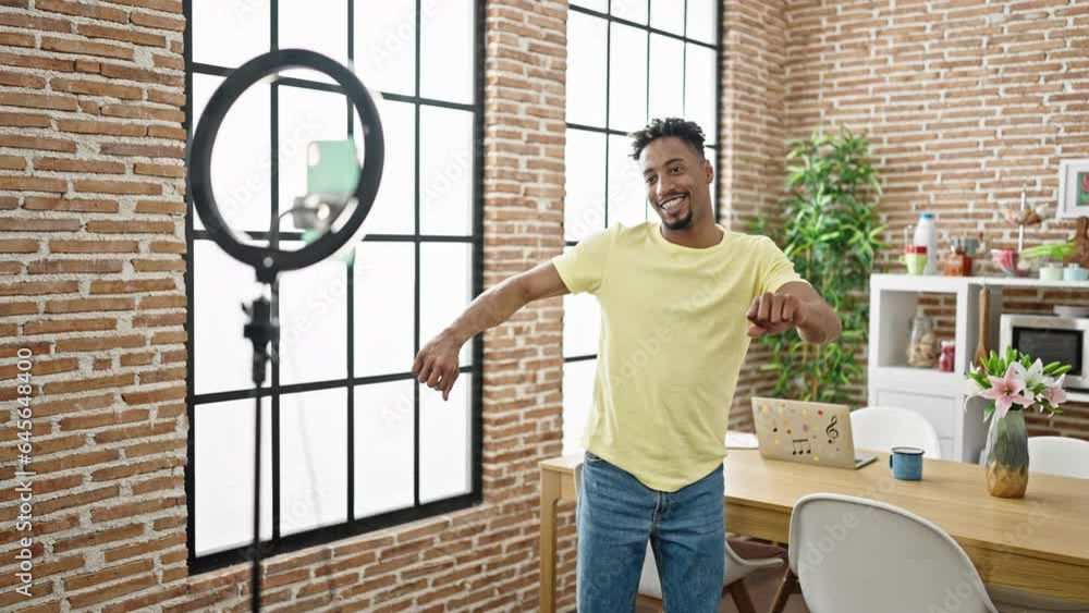 African american man smiling confident recording tutorial dancing at dinning room African american man smiling confident recording tutorial dancing at dinning room