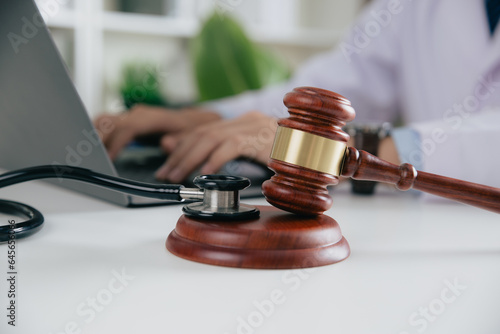 Gavel With Medical Stethoscope while doctor using laptop, Concept of medical law and medical crimes. photo