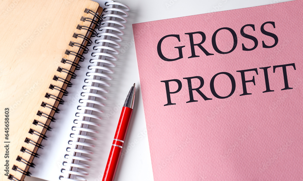 GROSS PROFIT word on the pink paper with office tools on white background GROSS PROFIT word on the pink paper with office tools on white background