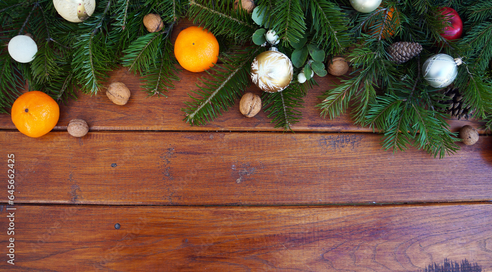 Christmas wooden background with snow, red baubles, oranges, fir tree and decoration. Top view with copy space for your text Christmas wooden background with snow, red baubles, oranges, fir tree and decoration. Top view with copy space for your text