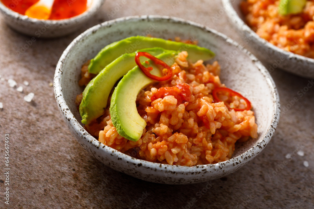 Spicy rice with avocado and chili sauce