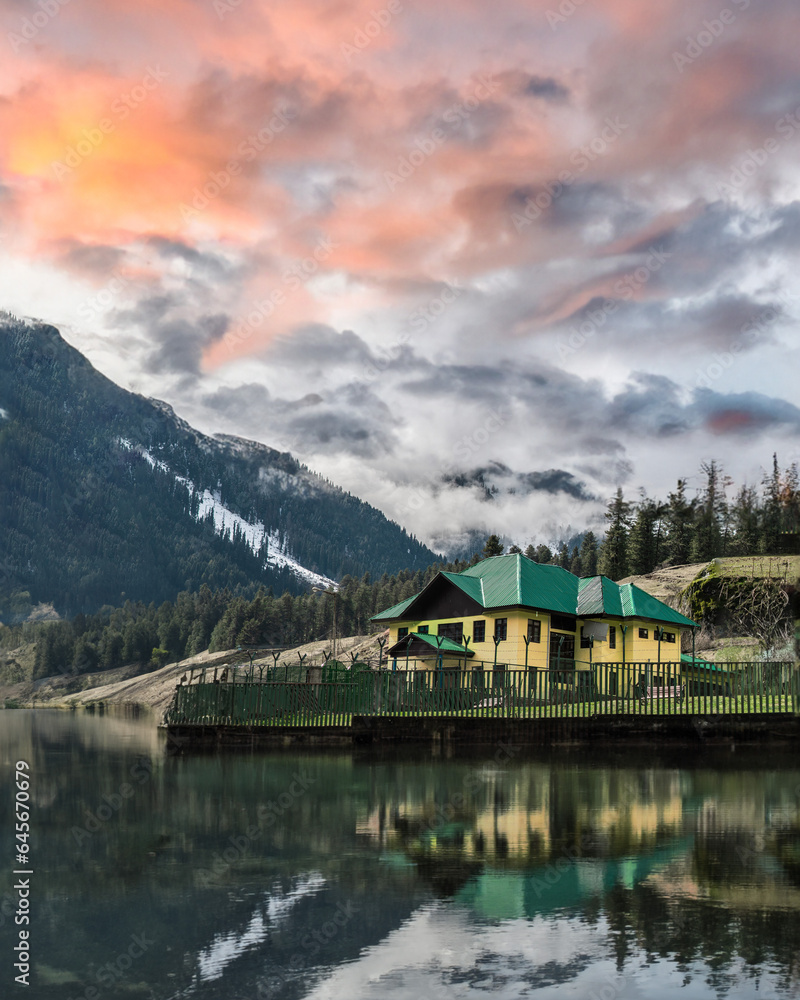 Mountain house in kashmir valley with hill peaks.