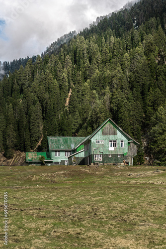 Mountain house in kashmir valley with hill peaks.
