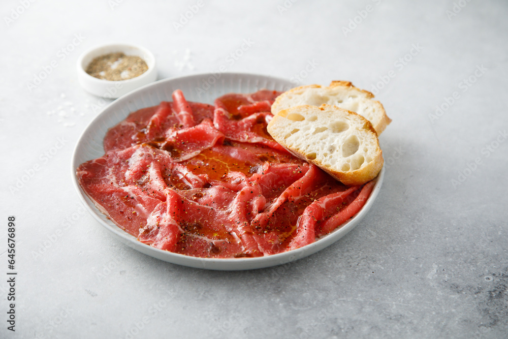 Traditional beef carpaccio with baguette bread Traditional beef carpaccio with baguette bread