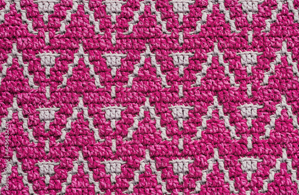 Knitted background. Magenta grey crochet texture with mosaic pattern.