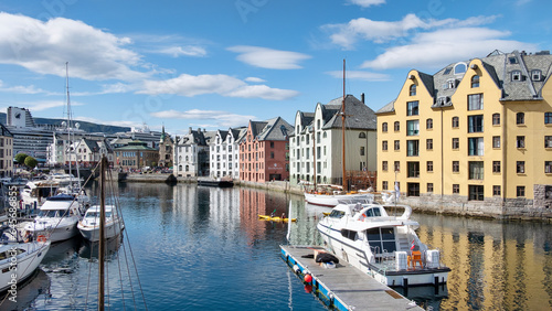 Picturesque view of the Brosundet Canal towards docked yachts and fishing boats, famous waterway crossing the old town lined with the beautiful art nouveau buildings, Alesund, Norway